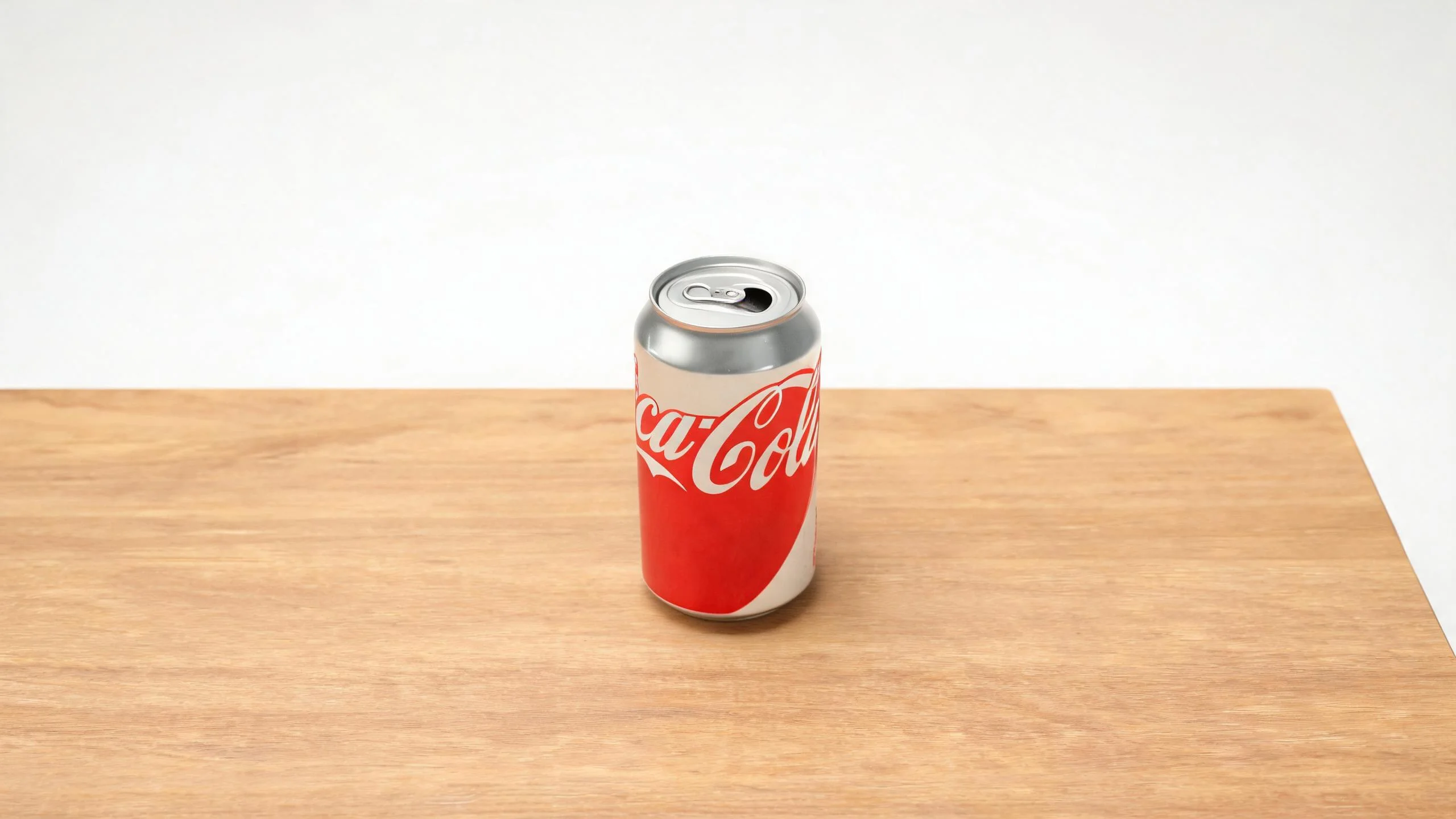 An ordinary drink can standing on a table against a plain white background with simple lighting.
